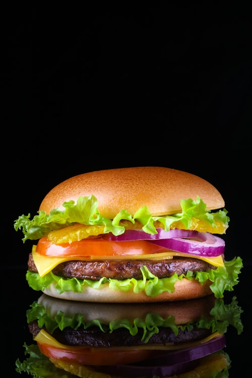 Cheeseburger with lettuce, tomato, onion, and pickle