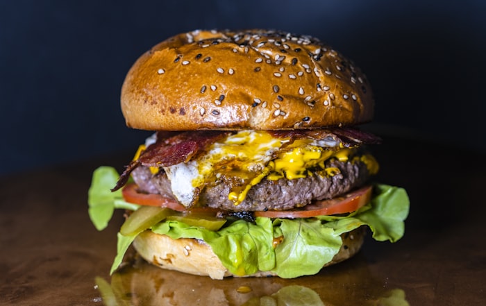 Burger with bacon, cheese, lettuce, and tomato