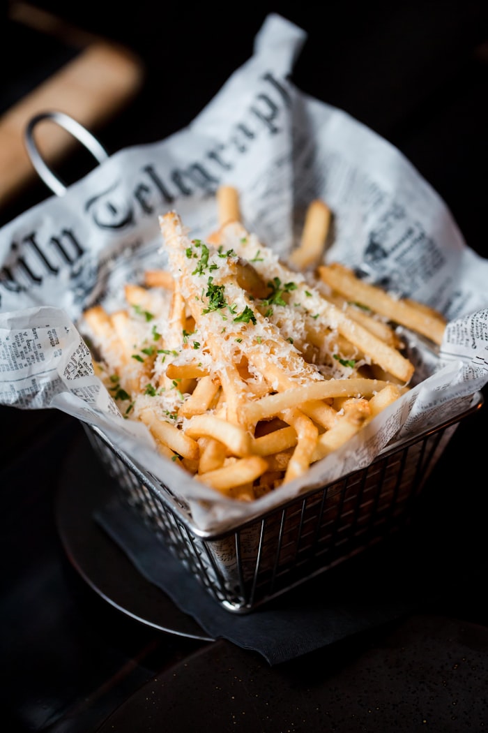 Fries topped with grated cheese and herbs