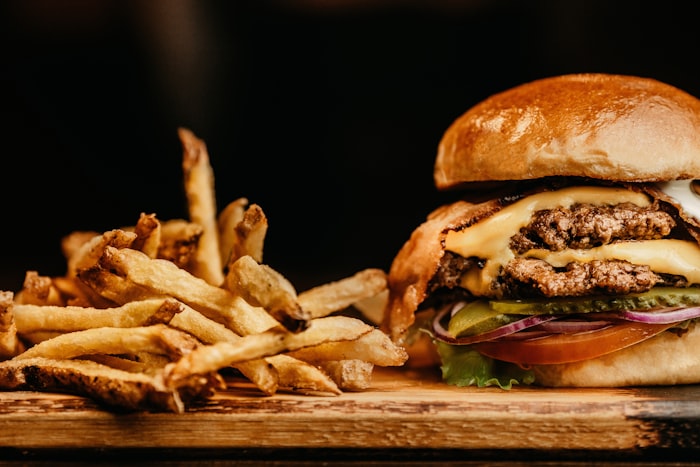 Double cheeseburger with fries on a wooden board